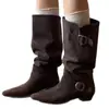 No entanto, o novo estilo de botas de cavaleiro apresenta um cano largo, uma fivela de cinto de couro, um acabamento em camurça, um efeito emagrecedor, um salto grosso, uma biqueira quadrada e um comprimento até a panturrilha.