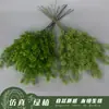Gran cantidad de plantas verdes artificiales en stock, incluyendo pino Penglai y pino gordo, para paisajismo, bodas temáticas de bosque y decoración de salones de ceremonia.