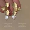 Pendientes de perlas de pétalos de metal retro francés de alta gama, diseño de nicho, suaves y elegantes, pendientes de viento frío.