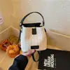 Bolso de paja tipo cubo nuevo estilo vacación de verano en la playa 2026, con un fresco diseño de patchwork en colores contrastantes y una textura tejida simple, un bolso para mujer