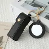 Mini llavero de lipstick portátil, bolsa redonda de cuero con espejo de maquillaje, accesorio para niñas, colgante de bolsa de espejo de maquillaje portátil