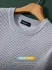 Minimalista e luxuosa, com uma textura canelada tridimensional, esta camiseta casual de manga curta possui gola redonda clássica e é perfeita como peça básica para o outono e inverno.