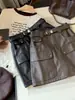 Saia curta estilo workwear retrô americano em couro PU para mulheres, nova coleção outono 2026, cintura alta, modeladora, versátil e em linha A.