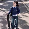 Conjunto Elegante Fresco Estilo College Patchwork Listrado Gola Falsa Duas Peças Top Desenho Animado Fofo Calça Jeans para Crianças Médias e Grandes