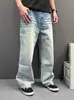 Calça jeans masculina de sarja azul claro com degradê, bainha curva, lavada e com aspecto desgastado, perna larga levemente flare, modelagem relaxada, calça casual versátil