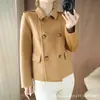 Abrigo corto de lana pura, simple y elegante, con solapa estilo traje y botones de doble botonadura, diseñado para disimular y estilizar la figura, un abrigo de lana indispensable para el lugar de trabajo.