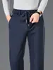 Calças casuais masculinas grossas, quentes e confortáveis para outono e inverno, com cós elástico, design de perna reta e tecido stretch, adequadas para homens de meia-idade, uso no trabalho e atividades esportivas.