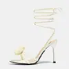 Venta al por mayor de fábrica Sandalias de tacón alto con cordones, punta redonda, decoración de flor tridimensional para mujer, transfronterizas europeas y americanas, tacones altos, sexys