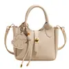 Diseño de nicho estilo coreano, simple y versátil, bolso de mano con patrón de lichi para mujer, nuevo bolso pequeño tipo cubo cruzado primavera 2026