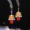 Nuevos aretes antiguos de borla de perlas de ágata roja de alta gama con sentido de alta gama, nuevos aretes de viento palaciego de linterna de palacio de pabellón chino de alta gama