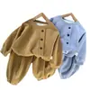 Conjunto casual simple estilo coreano para primavera y otoño para niños, que consta de una camisa de manga larga de color liso con botones y pantalones tipo jogger holgados.