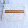 Tejido jacquard de algodón puro con estampado de lazos y flores pequeñas para ropa infantil, cortinas, faldas, diademas, coleteros y proyectos de manualidades.