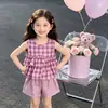 Artículos de fábrica en stock conjunto de dos piezas a cuadros para niñas blusa tipo muñeca con volantes chaleco sin mangas pantalones cortos sueltos casuales suministro