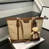 Bolsa tote grande com padrão de losangos em cores contrastantes e pingente de urso fofo, bolsa de ombro feminina versátil e moderna para o trabalho