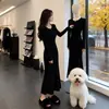 Elegante vestido negro de punto para mujer, diseñado para otoño e invierno, con cintura ajustada y silueta estilizada.