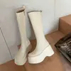 Primeiro encontro com botas femininas de sola grossa, de cano alto, com saltos extra-altos, bico redondo, cano longo, plataforma impermeável e material elástico.