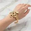 Pulsera abierta de lujo ligero vintage transfronteriza con relieve en espiral dorada, brazalete circular ancho con patrón de estilo europeo y americano de mediados de siglo