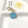Llavero de cara sonriente de color aleación con goteo transfronterizo de comercio electrónico, accesorios de colgante para bolso con expresión irregular chapado en oro