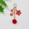 Llavero Colgante de Flor con Pompón Estilo Japonés Nuevo Estilo Transfronterizo Decoración de Estuche para Auriculares de Aleación con Goteo de Aceite Estilo Chanel