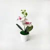 Plantas artificiales modernas y minimalistas en maceta con dos orquídeas, una grande y una pequeña, para decoración de sala de estar y alféizar de ventana en casa