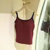 Camisole canelada minimalista versátil para o início do outono, com gola redonda, costas amplamente abertas e bojos embutidos, adequada para mulheres como camada interna ou peça externa.