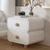 Mesita de noche de color crema con acolchado suave, esquinas redondeadas, doble cajón y patas de madera maciza, un mueble de almacenamiento simple y práctico para el dormitorio