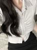 Camisa blanca estilo Spice Girl, corta, ajustada, con hombros descubiertos y cintura plisada, diseño de manga corta.