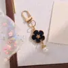 Nuevo llavero colgante de flor de esmalte colorido estilo INS, un accesorio de aleación de cara sonriente de doble cara creativo y versátil para DIY