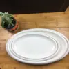Venta directa de fábrica de platos ovalados para pescado de cerámica blanca pura con borde grueso, adecuados para uso en hoteles, restaurantes y cenas en casa.