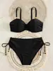 Traje de baño bikini negro estilo clásico europeo y americano con adornos de cuentas doradas, con cuello halter y cordones laterales, diseñado para un look de vacaciones
