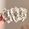 Pinza de plátano en forma de corazón Melard marrón, un accesorio para el cabello sofisticado y minimalista con un lazo y diseño floral