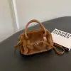 Bolso de mano para mujer estilo commuter, minimalista y sutilmente lujoso para el otoño de 2026, con un diseño afelpado, versátil para llevar al hombro o cruzado.