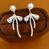 Aretes de perla con pasador de aguja de plata y circón, diseño de moño con goteo de aceite, multi-uso, aretes elegantes para el día a día con un toque de lujo ligero y alta gama