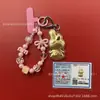 Llavero de tela con logo de empresa personalizado Cadena para teléfono móvil Angela Lámina de oro puro Oro 999 Regalo de aniversario