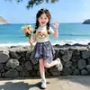 Conjunto de Camiseta de Manga Corta y Falda a Cuadros Nuevo Estilo Verano 2026 para Niñas Jóvenes, Conjunto de Dos Piezas Estilo Universitario para Niños