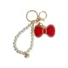 Llavero de lazo de moda con diamantes completos y cadena de perlas, un colgante lindo y brillante para bolsos, cadenas de teléfono y accesorios