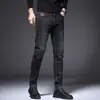 Jeans masculinos slim-fit pretos e cinzas de alta qualidade para o Outono/Inverno 2026, calças compridas casuais trendy e elásticas com forro de fleece