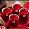 Um conjunto de xícaras de chá de casamento, incluindo um par de tigelas de chá e pauzinhos vermelhos e festivos, perfeito para servir chá durante a cerimônia de casamento.
