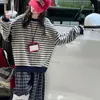 Coleção de outono: novo look casual para meninas, apresentando uma blusa de moletom listrada e calça xadrez, um conjunto de duas peças estiloso e moderno
