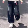 Elegante conjunto de dos piezas para niñas: top de retazos con expresión de dibujos animados para primavera y otoño, con un pequeño colgante de gato, combinado con pantalones vaqueros de moda.