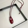 Blogger sul-coreana com colar longo oval vermelho vinho preto explosão nicho alto pingente acrílico corrente de suéter