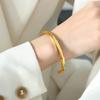 Pulsera abierta de acero de titanio chapado en oro con diseño de línea de torsión geométrica elegante para viajeros de moda