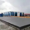 No inverno, o dispositivo de limpeza de pneus com saída de água de alta pressão para veículos modernos no portão do parque logístico é utilizado.