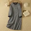 Foto real de un vestido para muñeca de estilo japonés, con un diseño a cuadros plisados estilo Mori, un vestido de longitud media, artístico y vintage inspirado en la estética Mori girl, con cierres de botones.