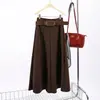 A Feiyuan oferece uma saia evasê simples e elegante com cós largo, em cor sólida.. Esta nova coleção outono/inverno apresenta uma saia longa de mistura de lã de cintura alta, modeladora e versátil.