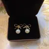 Aretes Colgantes con Lazo Dorado y Perla de Agua Dulce Natural para Mujer Verano Retro Francés Nicho Sentido de Alta Gama Pendiente Nuevo Estilo
