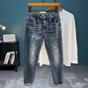 Calça Tapered Xintang Denim Outono/Inverno 2026 com Bordado, Detalhes Rasgados e Desgastados, Jeans Stretch Azul Vintage Longo para Homens, Nova Chegada