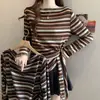 Camiseta Listrada de Manga Longa Feminina Plus Size com Tiras para Amarrar, Barra Irregular, Novo Estilo Primavera/Outono, Caimento Solto, Emagrecimento, Top Interno que Marca a Cintura