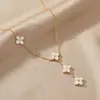 Nuevo collar de acero de titanio color dorado transfronterizo que no se decolora con cuatro margaritas de concha blanca, moderno y versátil, collar de borlas de nicho