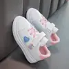 Nueva colección primavera y otoño 2025: Tenis para niñas con correas de velcro, con diseño de corazón, color blanco y suelas suaves, perfectos para uso casual y actividades deportivas.